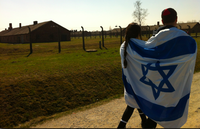 EXPERIENCE:  Members of the class of 2013 were wrapped in the Israeli flag at Auschwitz last April on the senior Poland-Israel trip. The endowment will hopefully make it possible for more seniors to attend the trip.