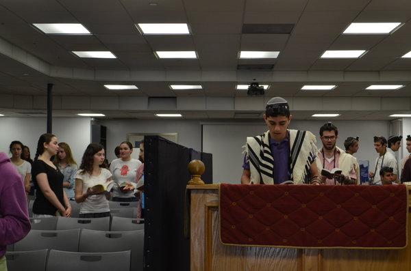 FOCUS: During Shacharit earlier this month, freshman Eric Bazak read the prayer for the sick as Reb Tuli Skaist looked on.  It was added earlier this year after parents of several students were diagnosed with serious illness.