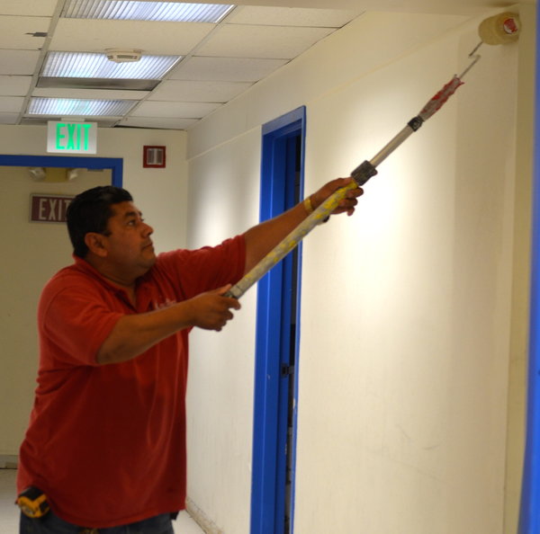 GETTING READY: Maintenance chief Jose Flores applied new paint to a hallway in the Annex. 