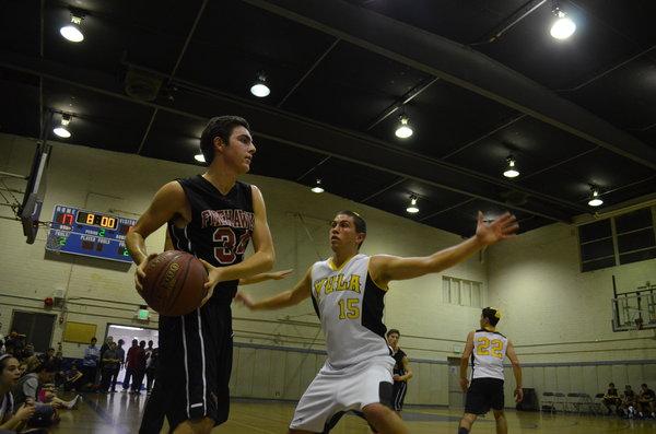 INBOUND: Sophomore Jacob Dauer tries to inbound the basketball against Ariel Sokol of YULA in the annual rivalry game. The girls’ team played before the boys and won 59-40, while the boys lost 62-36.