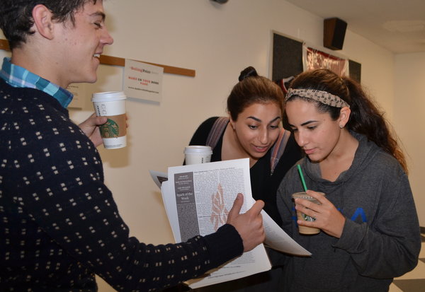 SPARKS:  Sophomore Micah Gill, founder and editor of Nitzotzei Torah, hands out copies to juniors Jillian Einalhori and Shana Chriki Feb. 21.