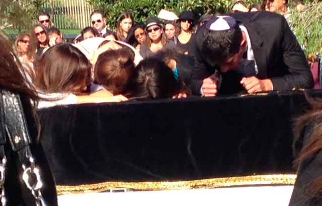 TOO SOON: Morah Michal Davis, left, grieving  at her husband's coffin with their children July 13.