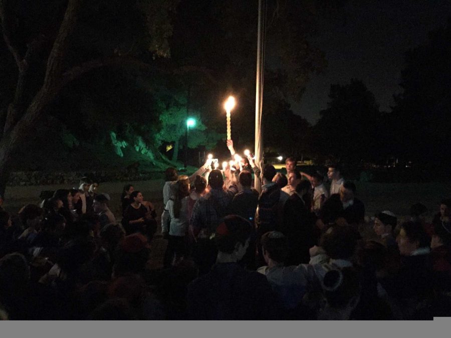 FLAME: Seniors held candles during Havdalah at the school Shabbaton Nov. 14 at Camp Max Strauss in Glendale.