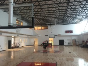INDOOR GYM: State-of-the-art gym has a regulation basketball court and volleyball court, along with pulldown bleachers along the right-side wall and natural light pouring in from windows as long as the room.  A new Firehawk logo is on the floor at center court. 