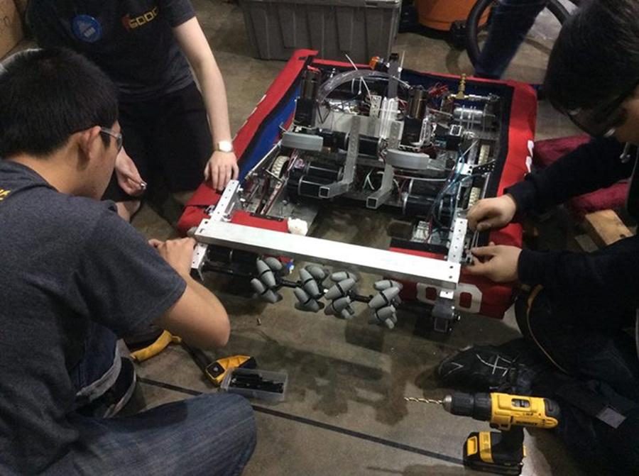 Team members perform small fixes on the robot in preparation for an FRC match. The team won 6 of 8 matches. 
