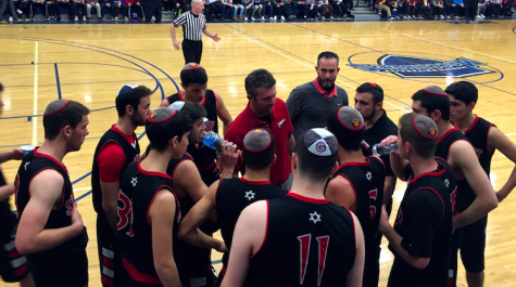 CONFER: FIrehawk players  met with Coach Ryan Coleman during the championship game at the Red Sarachek Tournament March 6 at Yeshiva University.