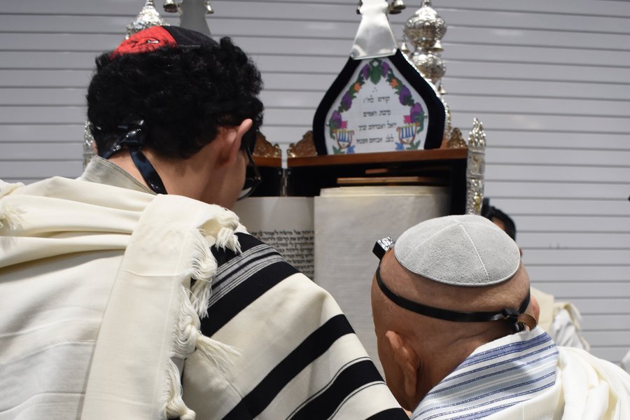 SCROLL: Senior Ilan Bouskila was first to chant from the scroll. Sephardic Torahs are read standing vertically, while Ashkenazic Torahs are read lying flat on the table.