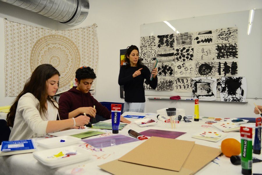 EXPLORE: Mrs. Samantha Garelick, right, explained to Michelle Navi and Yehudah Zadeh in the new art room, B102. 