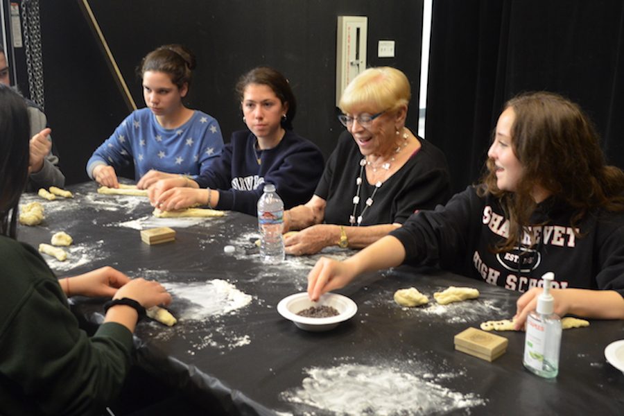  BRAID:   Ms. Yona Nadelman, second from right, described her Holocaust experiences while making bread with students in the Wildfire Theater May 17. The event was sponsored by the Los Angeles Museum of the Holocaust and led by Shalhevet sophomore Noa Nelson. 