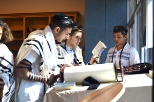 CHANT:   Senior Jeremy Ashagian chanted from the Torah scroll as Rabbi David Block followed along watching for errors. Many students know how to do this, and a few do it professionally on a regular basis at synagogues like B’nai David-Judea and Young Israel of North Beverly Hills.