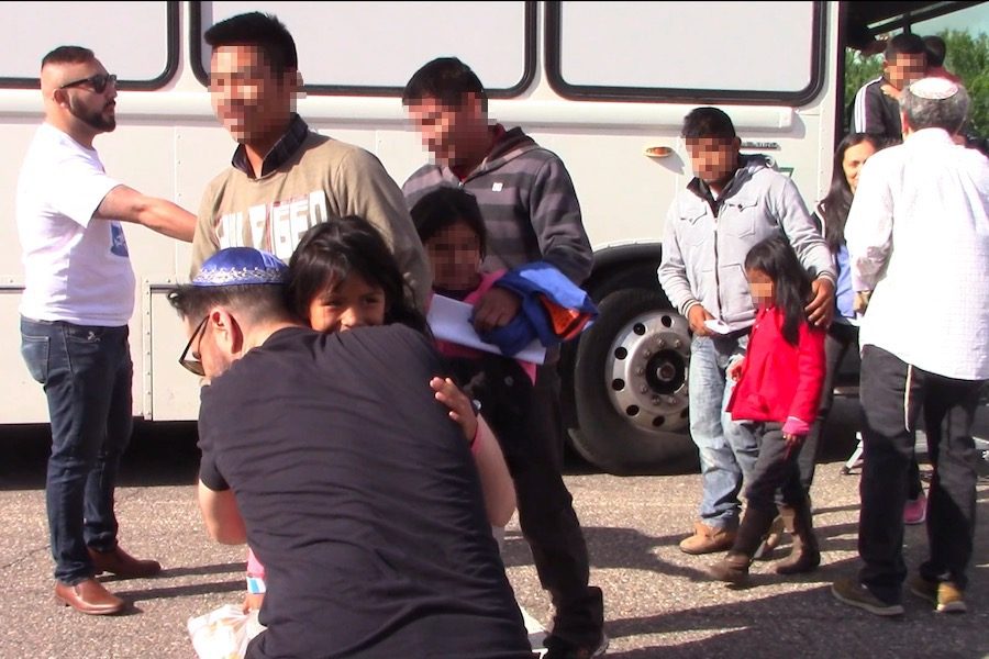 WELCOME: A young girl from Central America is welcomed by Shalhevet parent Mordechai Fishman after she stepped off the bus in Phoenix.