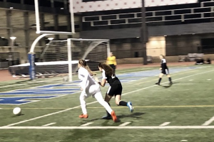 PURSUIT: Freshman forward Vivienne Schlussel charges the ball as a YULA defender trails her. The Firehawks went on an offensive tirade last week, beating the Panthers 8-0 ahead of their playoff game versus Buckley tomorrow.