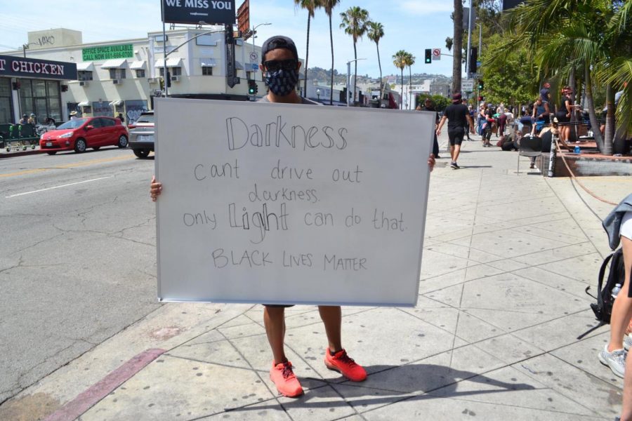 A protestor carried a  home-made sign on Fairfax Avenue Sunday afternoon.