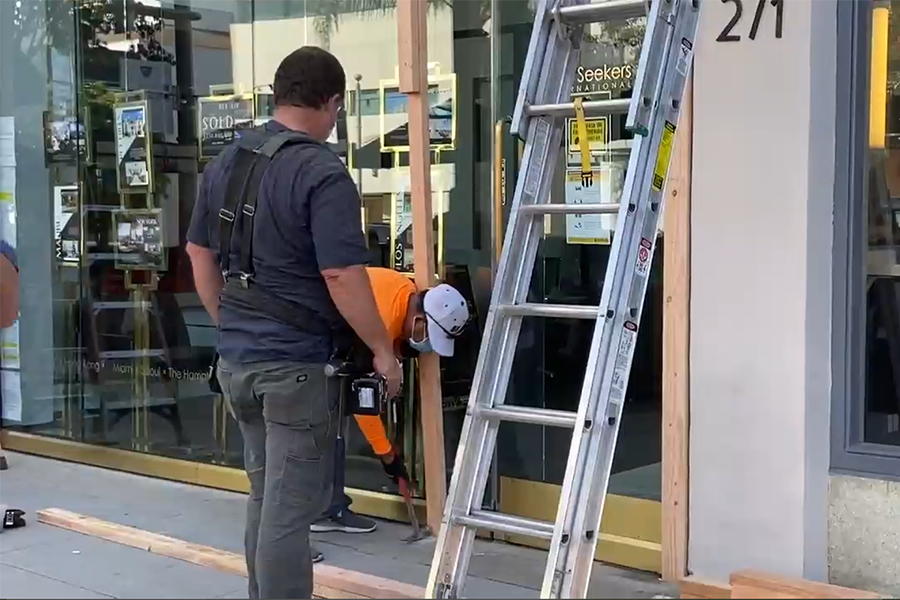 PREPARE: On the day before the presidential election, workers built a wooden frame to protect the glass storefront of The Rooster restaurant on Pico Boulevard.