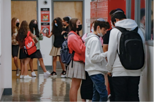 BACK: Students filled the second-floor hallway above the gym last month, most wearing masks. “Like when someone reminds me, I immediately pull it up,” one student said.