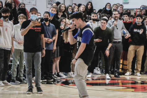 HYPE: Junior Dani Kunin cheers into the microphone during the pep rally Friday as students and players get excited for the upcoming Steve Glouberman Basketball Tournament, which starts Nov. 3.