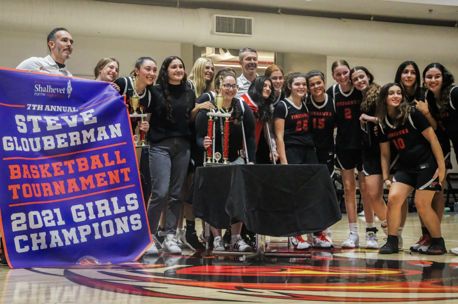 CHAMPIONS: The girls Firehawks posed with the winning banner, joined by alumna Hilla Lasry ‘21 who was unable to play in Glouberman last year due to the pandemic.
