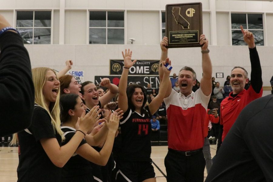 CELEBRATE: Coach Coleman holds up the Southern Regional Champions trophy as the Firehawks look to face the San Domenico Panthers in the State Championship tomorrow morning. 