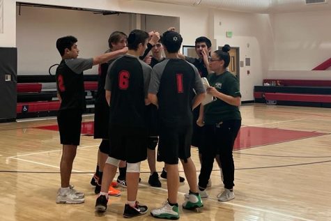 EXCITEMENT: Boys Volleyball team huddles together with Coach Jelly Castellanos after a three to zero win over the Animo Leadership Aztecs, ensuring a spot in the playoffs, April 13.