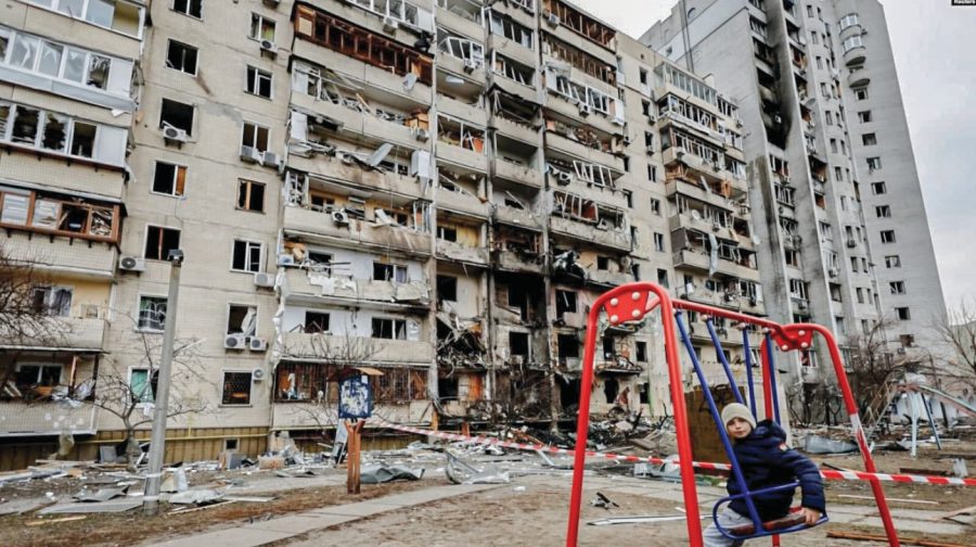 BEGINNING: A child walked near a destroyed residential building in Kyiv on Feb. 25, the second day of the war. Russias unprovoked invasion of Ukraine surprised people in both countries.