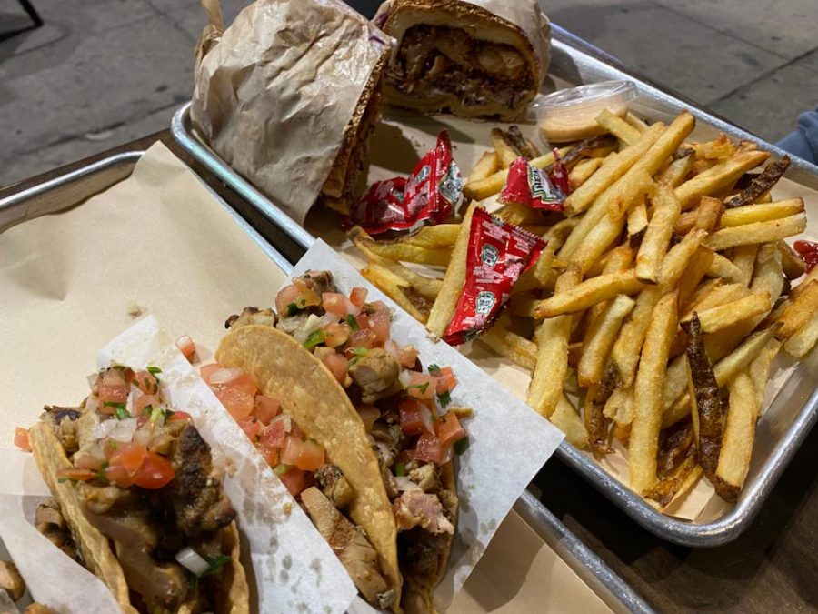 MEAL: The fried chicken sandwich with its included side of fries, priced at $24, and three chicken chalupas, priced at $18, sit on a table positioned at the edge of the sidewalk. 