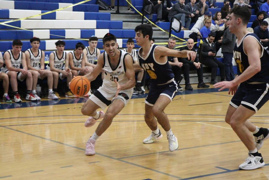 PRESSURE: Senior Avi Halpert attempts to dribble around Magen David defenders in Fridays victory over the Warriors. The Firehawks struggled in the second and third quarters but won 59-55.