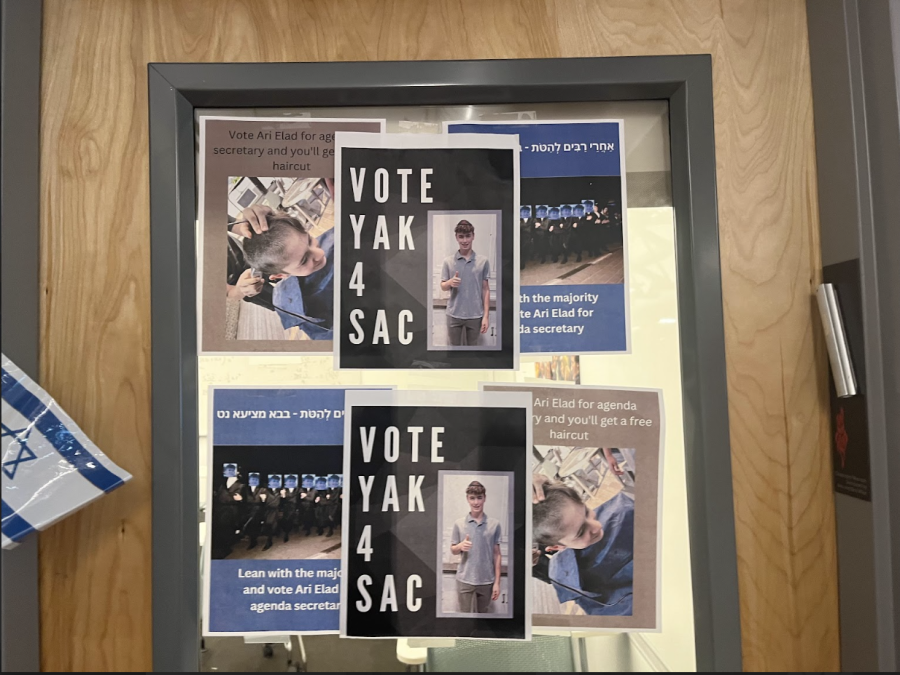 CAMPAIGN: Slogans in English and Hebrew adorned flyers on the door to Ms. Kong’s room, advertising candidates for Agenda and SAC in the second-floor hallway.
