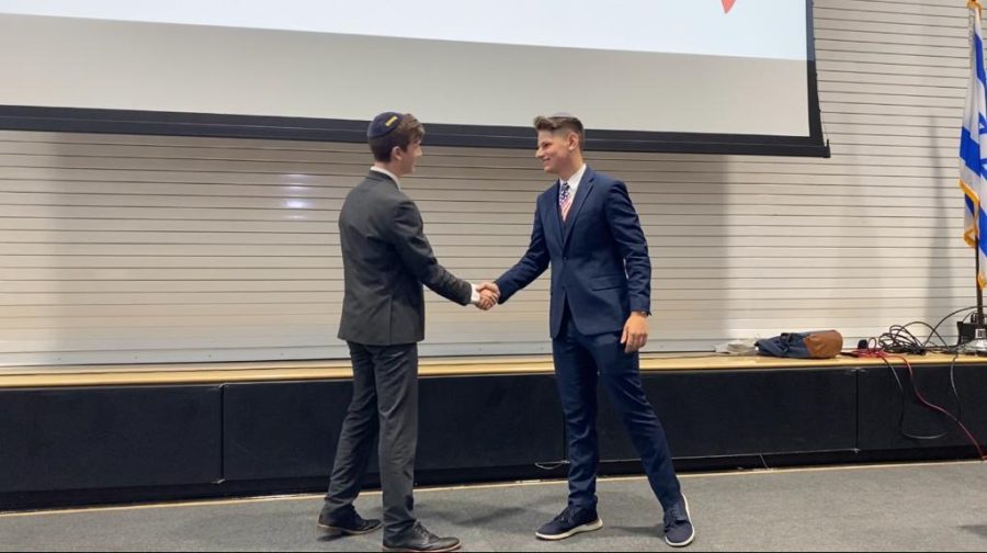 FRIENDS: Fellow juniors and Agenda Chair candidates Zion Schlussel and Rami Melmed shook hands at the end of a lively debate April 28 in the gym. 