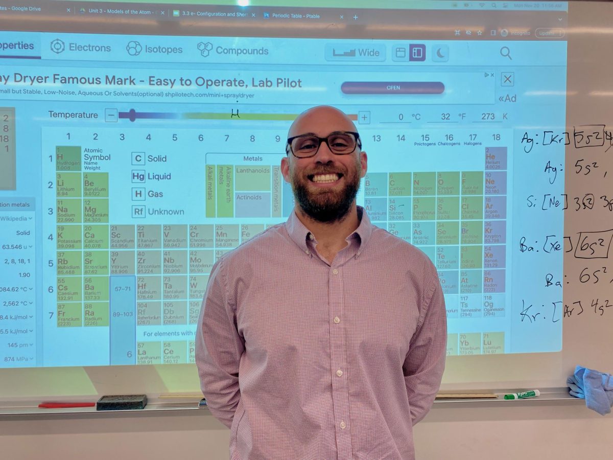 TEACHING: Mr. Justin Khalil stands in front of the whiteboard for a picture after teaching his 10th grade Honors Chemistry class on Nov. 20. 