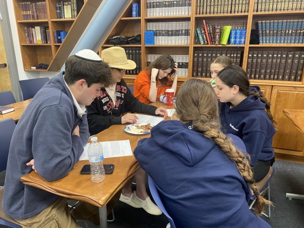 CHAVRUTA: Juniors and sophomores enjoy chicken wings with barbecue sauce while studying texts with Dr. Sheila Keiter Feb. 22 in the Beit Midrash.