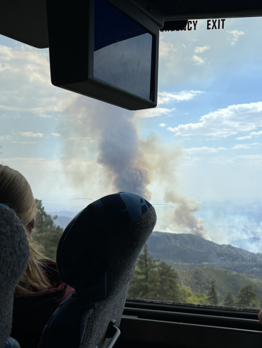 PEERING: Freshman Dalya Berg looks out the bus window at a tower of smoke in the distance. On the drive up to Camp Moshava Alevy on Friday afternoon, students and teachers saw smoke and fire on nearby mountains, so faculty contacted the Running Springs Fire Department as soon as they arrived. 